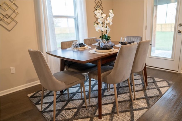 dining area featuring baseboards and dark wood-style flooring