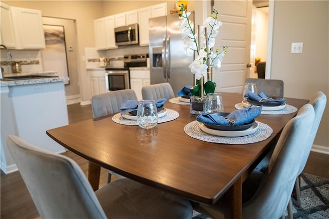 dining room with dark wood finished floors and baseboards