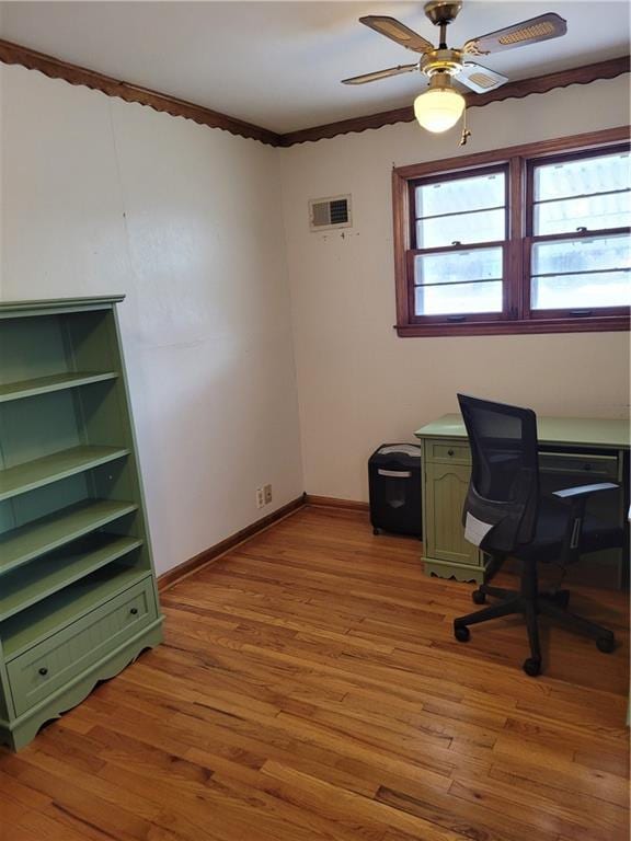 office space featuring light wood finished floors, visible vents, baseboards, and a ceiling fan