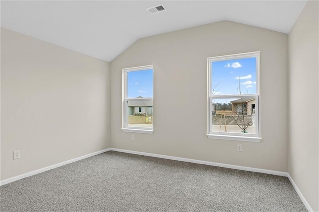 spare room with vaulted ceiling, visible vents, and a healthy amount of sunlight