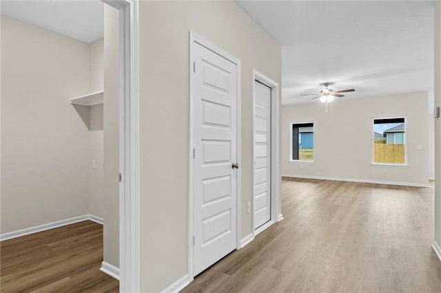 hallway with baseboards and wood finished floors