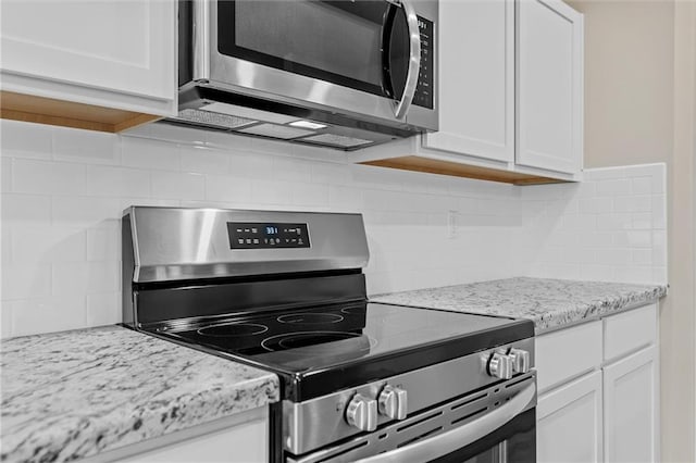 kitchen with white cabinets, tasteful backsplash, and stainless steel appliances