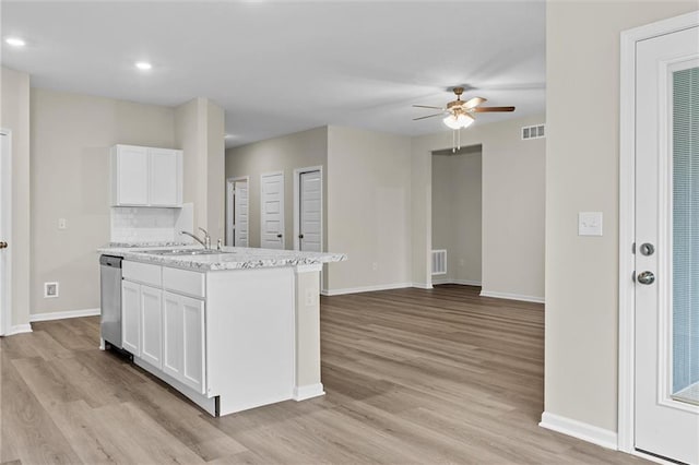 kitchen featuring visible vents, baseboards, white cabinets, stainless steel dishwasher, and light wood finished floors