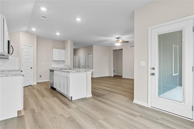 kitchen featuring dishwasher, an island with sink, light wood-style flooring, ceiling fan, and white cabinetry