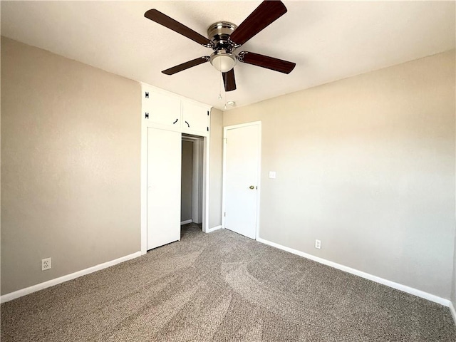 unfurnished bedroom featuring carpet floors, ceiling fan, baseboards, and a closet