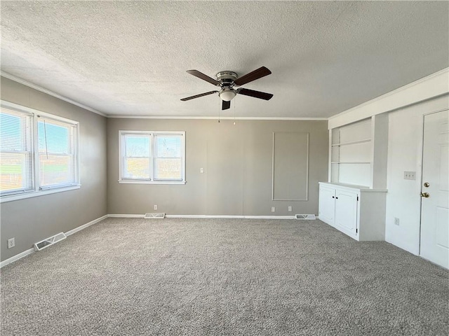 unfurnished room with visible vents, a ceiling fan, ornamental molding, a textured ceiling, and carpet floors