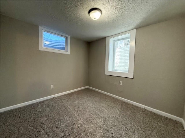 basement featuring carpet flooring, a textured ceiling, and baseboards