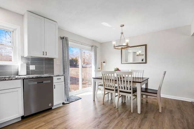 dining space with light wood-style flooring, baseboards, and a chandelier