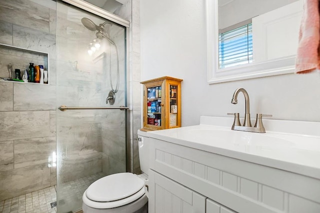 bathroom with toilet, a shower stall, and vanity