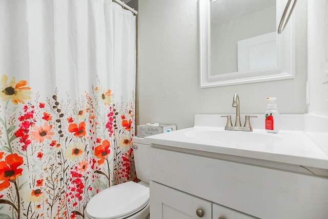 bathroom featuring toilet, a shower with shower curtain, and vanity