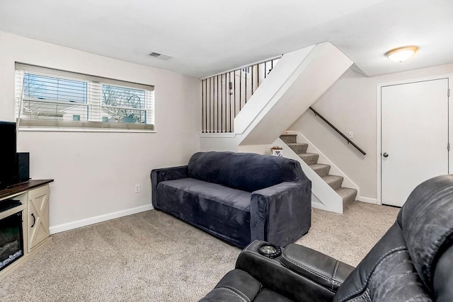 living area with carpet floors, visible vents, stairs, and baseboards