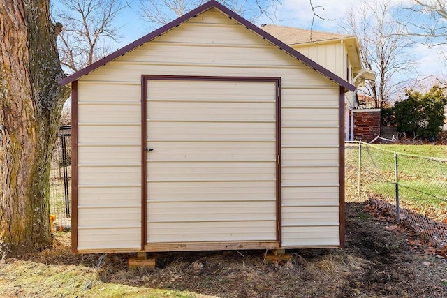 garage featuring fence and a storage unit