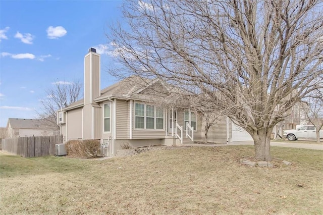 view of front of house with a garage, a chimney, fence, a front lawn, and central AC