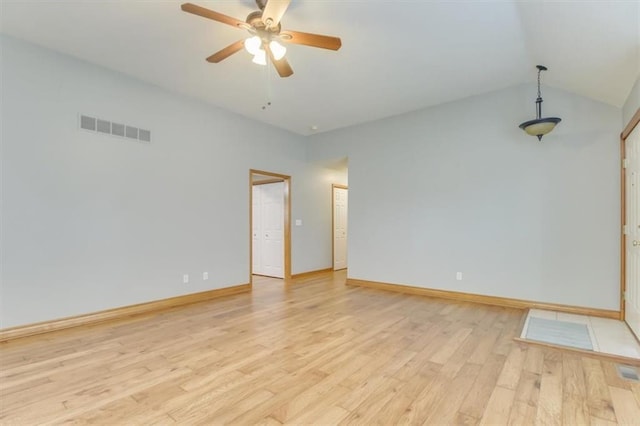 empty room featuring baseboards, visible vents, a ceiling fan, vaulted ceiling, and light wood-type flooring