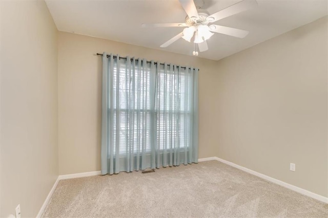 spare room with ceiling fan, carpet flooring, and baseboards