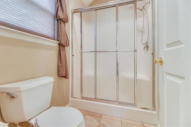 full bath with tile patterned flooring, a shower stall, and toilet