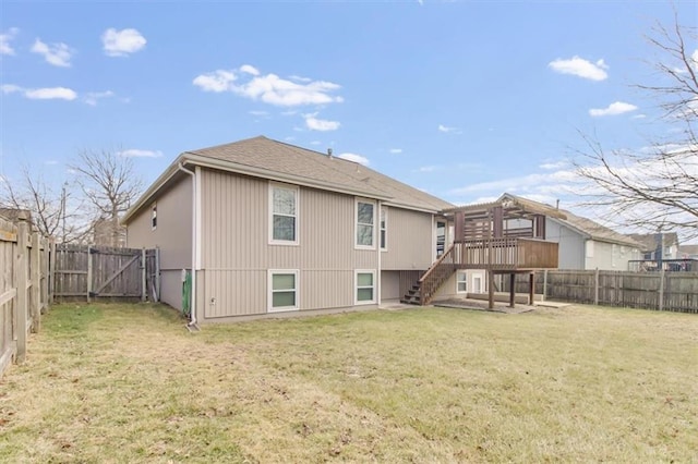 rear view of house with a fenced backyard, stairway, a lawn, and a wooden deck