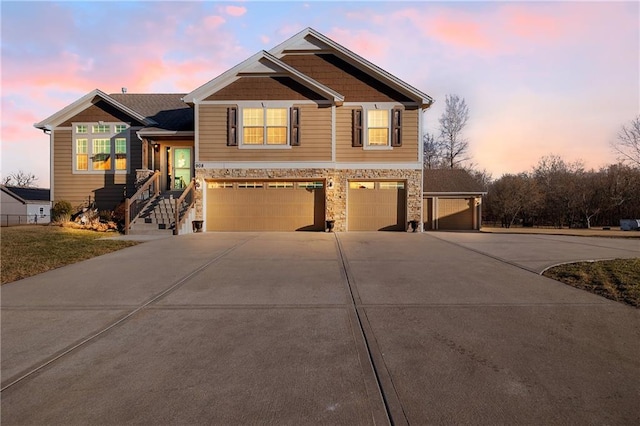 view of front of property featuring a garage, stone siding, and concrete driveway