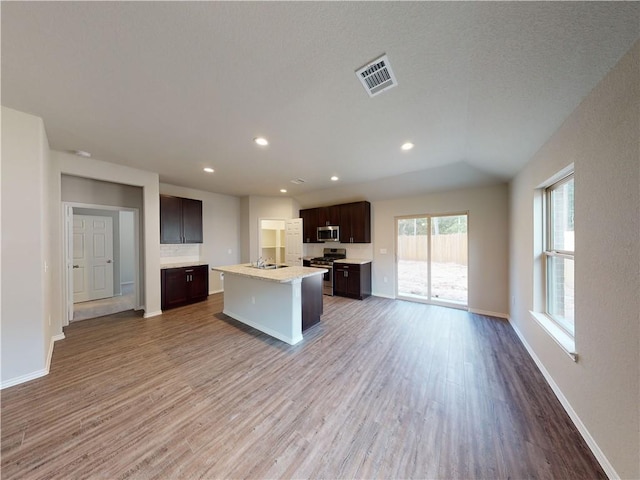 kitchen featuring appliances with stainless steel finishes, open floor plan, visible vents, and wood finished floors