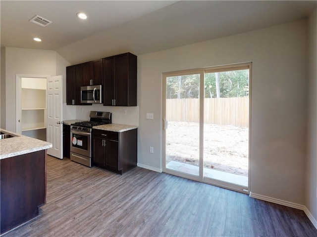 kitchen with stainless steel appliances, wood finished floors, light countertops, and visible vents