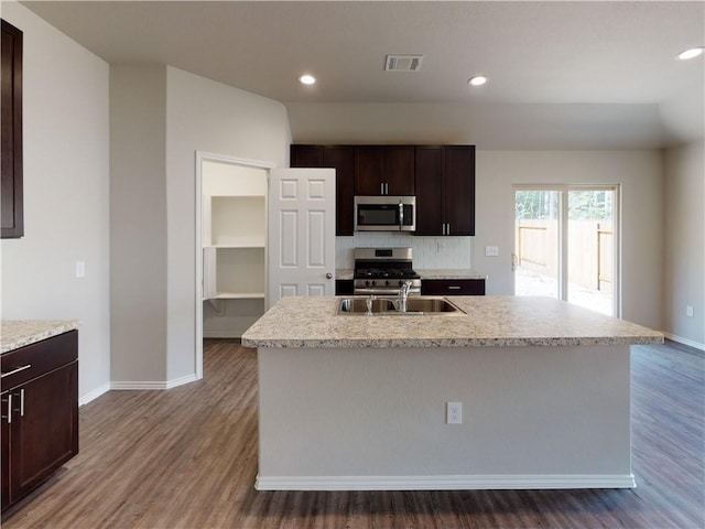 kitchen with wood finished floors, appliances with stainless steel finishes, a sink, and visible vents