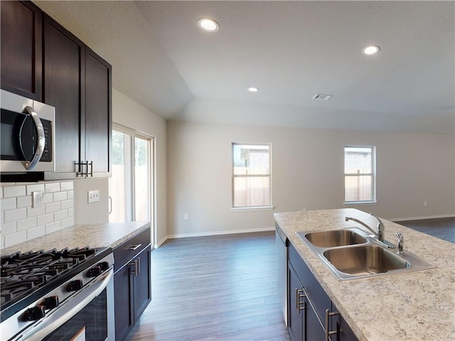 kitchen featuring stainless steel appliances, plenty of natural light, a sink, and decorative backsplash