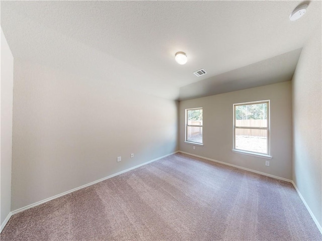 spare room with carpet, baseboards, and visible vents