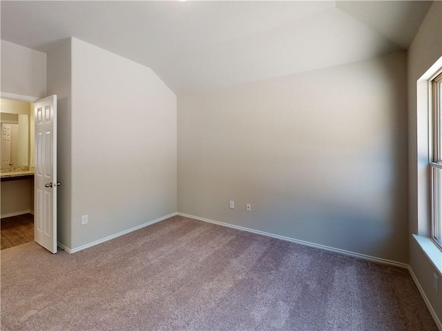 interior space with vaulted ceiling and baseboards