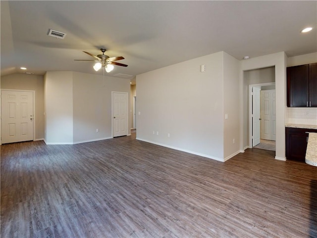 unfurnished living room featuring a ceiling fan, visible vents, baseboards, and wood finished floors