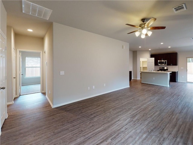 unfurnished living room with dark wood-style floors, a wealth of natural light, and visible vents