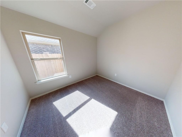 spare room featuring carpet floors, baseboards, visible vents, and vaulted ceiling