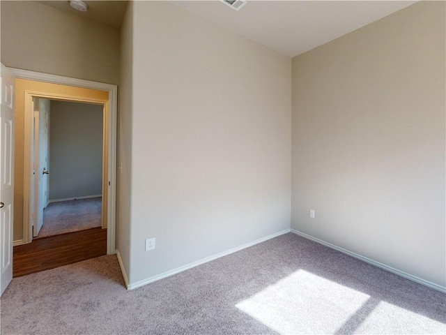 carpeted empty room featuring baseboards