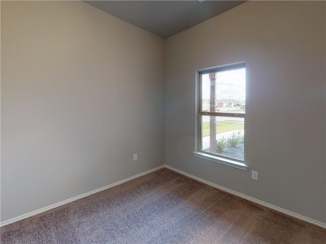 spare room featuring carpet and baseboards