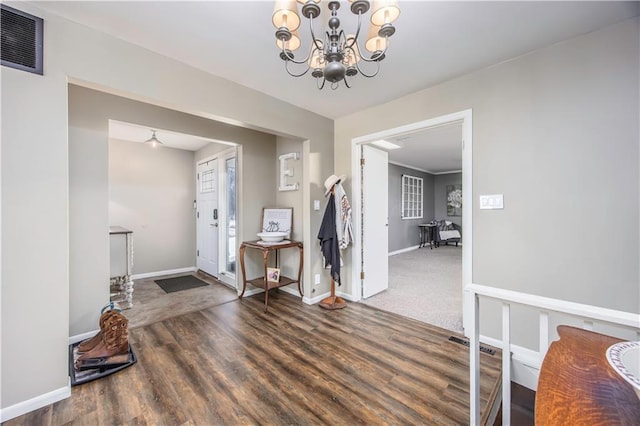 entrance foyer featuring a chandelier, visible vents, baseboards, and wood finished floors