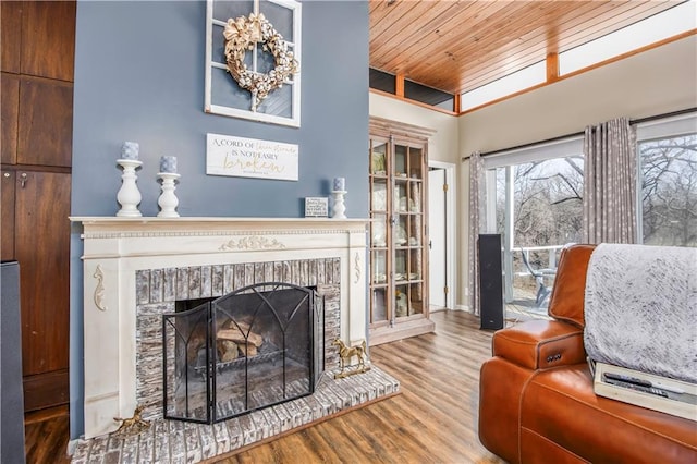 living area with wooden ceiling, wood finished floors, and a fireplace