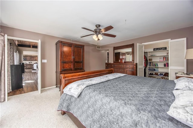 bedroom featuring light carpet, baseboards, and ceiling fan