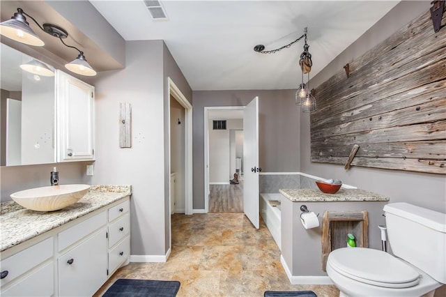 full bath with vanity, toilet, a bath, and visible vents