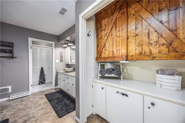 bathroom with visible vents, vanity, and baseboards