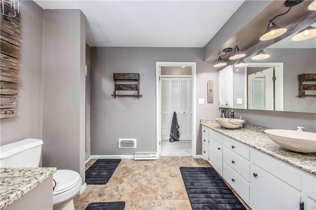 bathroom featuring a sink, visible vents, baseboards, and toilet