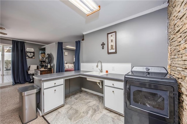 kitchen featuring a sink, washer / dryer, white cabinets, and crown molding