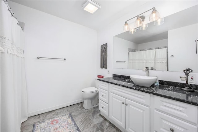 bathroom featuring baseboards, toilet, and vanity