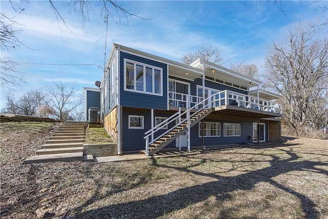 back of house featuring stairs and central AC unit