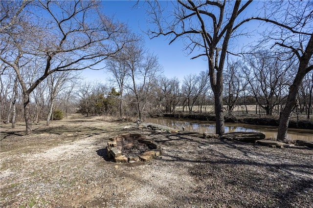 view of yard featuring an outdoor fire pit and a water view