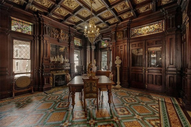 wine room with a chandelier, a fireplace, coffered ceiling, and a towering ceiling