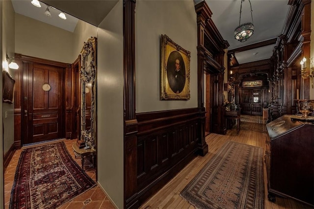 hallway with light wood-style floors and wainscoting