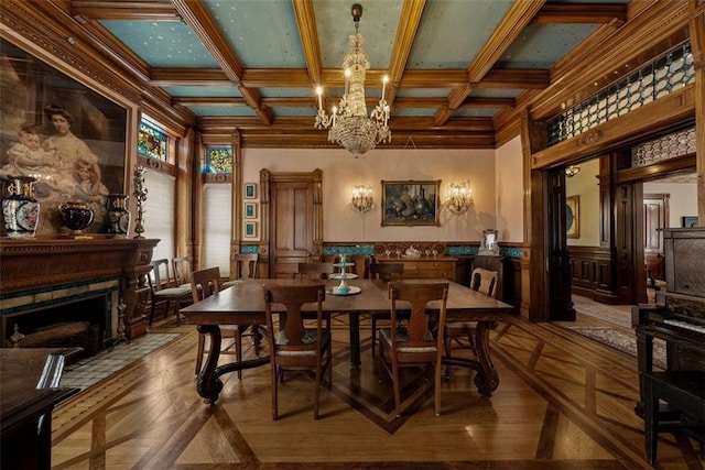 dining room with a wainscoted wall, a fireplace with flush hearth, a chandelier, and coffered ceiling