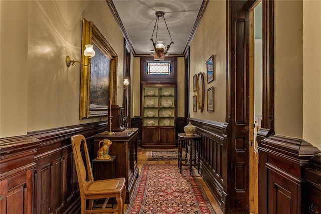 interior space with a wainscoted wall and crown molding