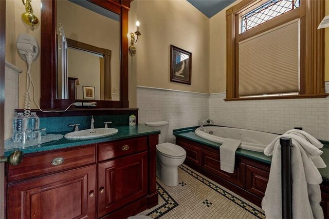 bathroom featuring wainscoting, a garden tub, tile patterned flooring, vanity, and tile walls