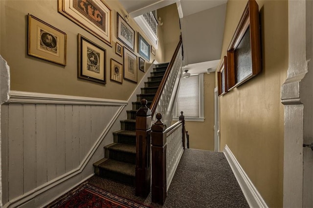 staircase with carpet and wainscoting