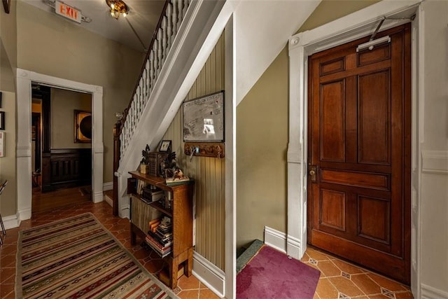 foyer with baseboards and stairs